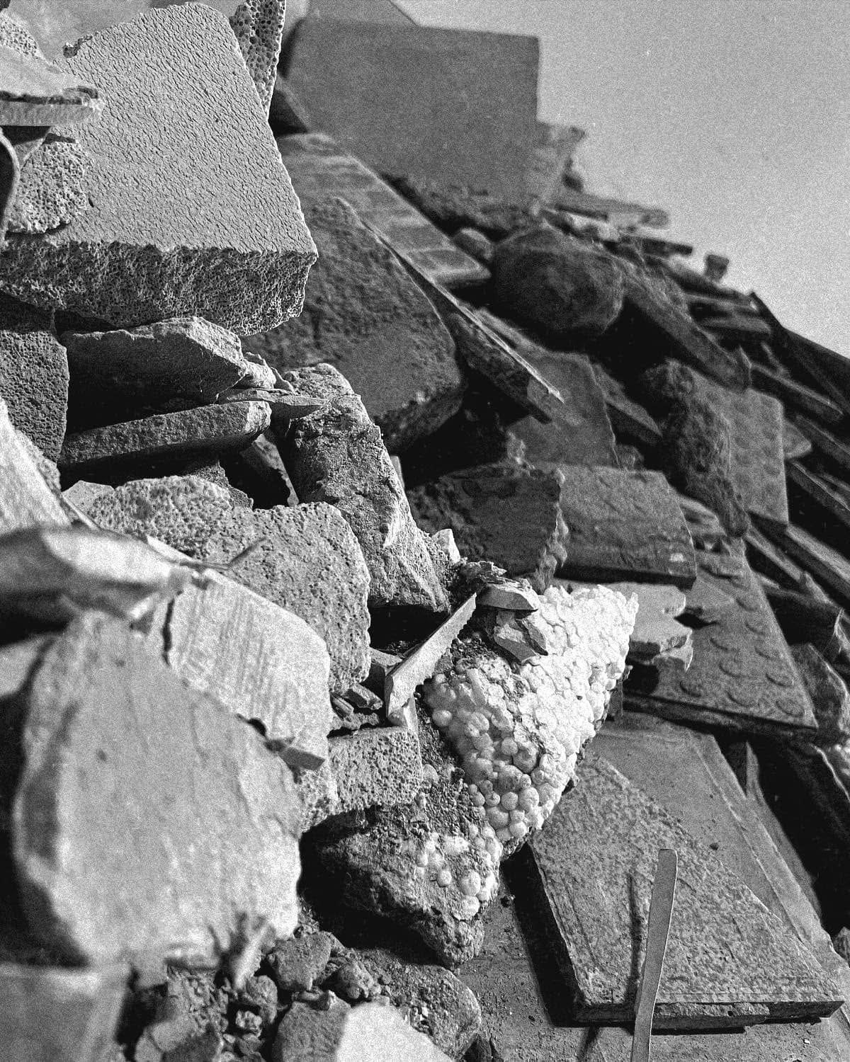 Schwarzweißfoto vom Umbau: ein Haufen Bauschutt aus alten Fliesen und Mauerwerk